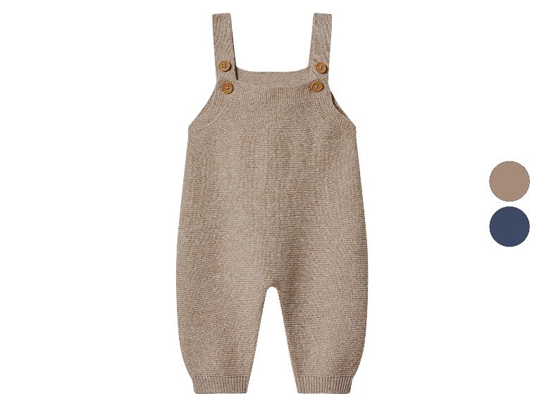 Gestrickter Baby-Strampler in Beige mit Holzknöpfen und Farbmustern.
