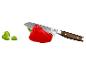 Rote Paprika und Messer mit Holzgriff, daneben Basilikumblätter.