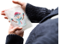 Hände halten einen Handwärmer mit Schneemannmotiv.