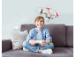 Ein Junge sitzt auf dem Sofa und steuert einen Quadrocopter mit einer Fernbedienung.