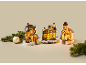 Beleuchtetes Weihnachtsdorf mit Häusern, Kirche und Tannenzweigen