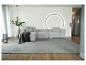 Modernes Wohnzimmer mit grauem Modulsofa, grauem Teppich und minimalistischer Dekoration.