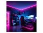 Ein Gaming-Zimmer mit neonpinken und blauen Lichtern, einem Gaming-Stuhl und mehreren Monitoren.