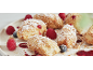 Donuts bestäubt mit Puderzucker und Streuseln, mit Himbeeren und Heidelbeeren.