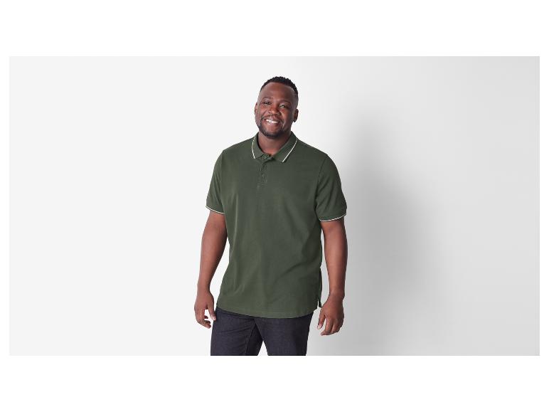Ein Mann trägt ein dunkelgrünes Poloshirt.