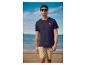 Mann in marineblauem T-Shirt und beiger Shorts am Strand.