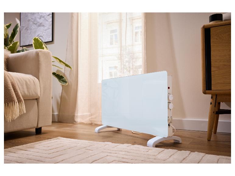 Weißer Standheizer in einem modernen Wohnzimmer mit Sofa und Pflanzen.