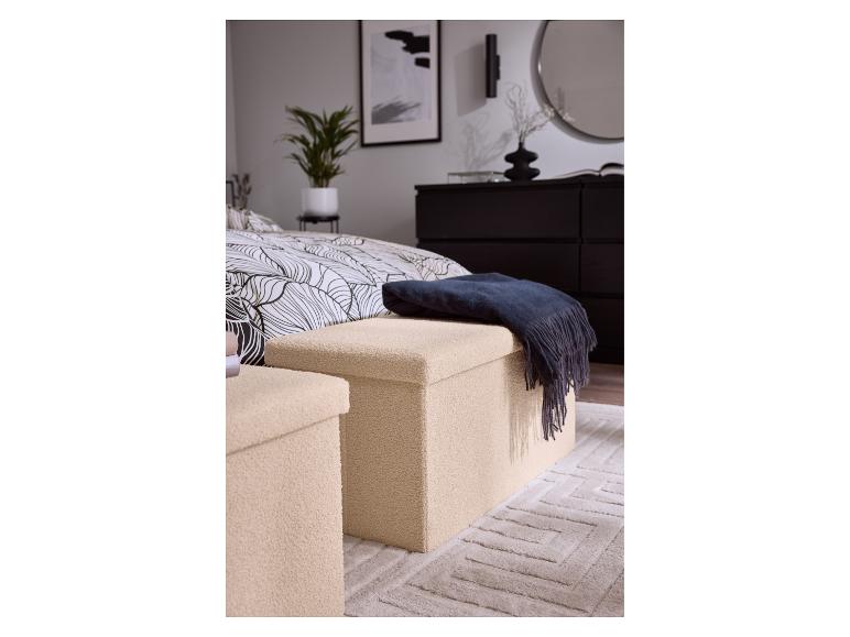 Zwei beige Aufbewahrungshocker mit einer dunkelblauen Decke in einem Schlafzimmer.