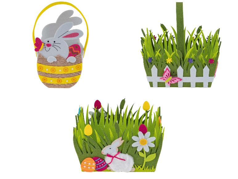 Drei Osterkörbe mit Hasen, Eiern und Gras.