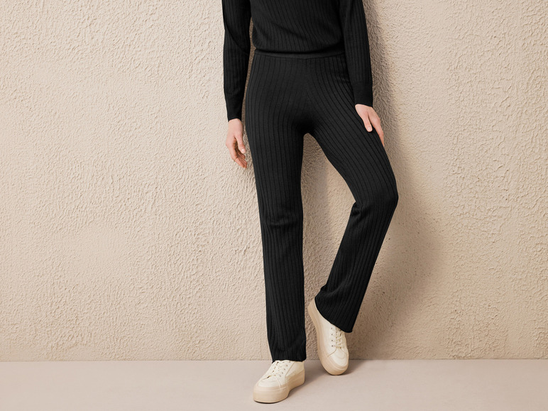 Schwarze Strickhose und weiße Sneaker.