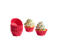 Zwei Cupcakes mit Streuseln und ein Stapel roter Silikon-Muffin-Förmchen.