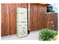 Beige Regenwassertonne an einer Holzwand.