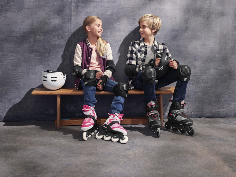 Zwei Kinder mit Inline-Skates, Schutzkleidung und einem Helm der Marke Crivit.