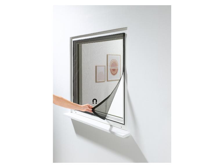 Eine Hand schließt ein magnetisches Fliegengitter an einem Fenster.