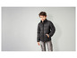 Ein Junge trägt eine schwarze Steppjacke und graue Cargo-Jeans.