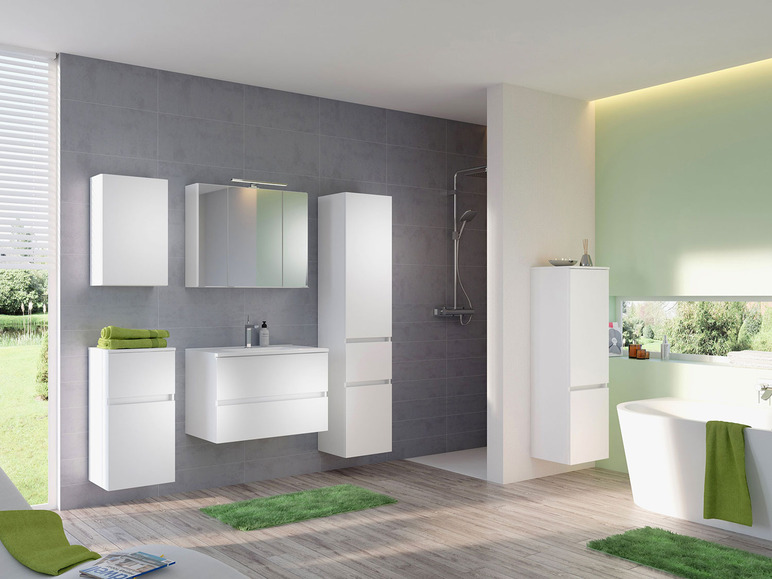 Badzimmer mit weißen Badschränken, einem Waschbecken und einer Badewanne.