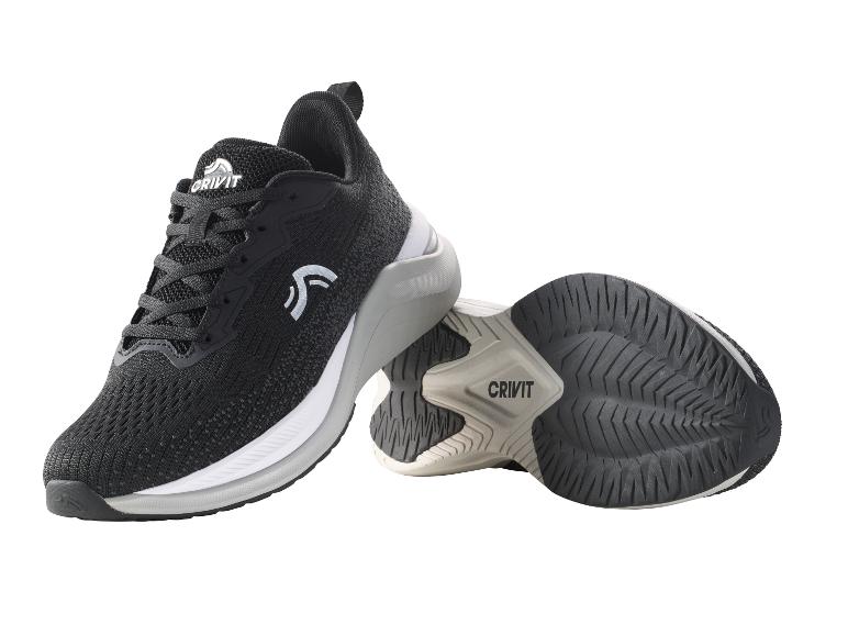 Schwarze Sportschuhe mit weiß-grauer Sohle, nebeneinander liegend.