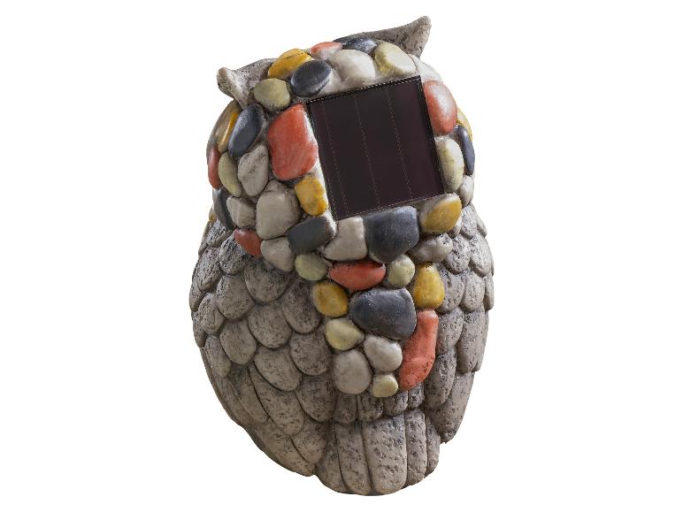 Eine steinerne Eule mit Solarpanel.