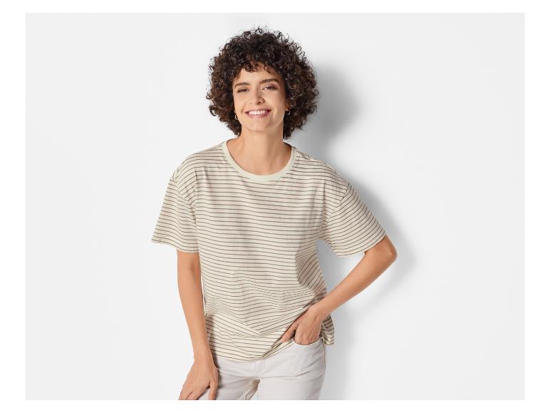 Eine Frau trägt ein gestreiftes T-Shirt und weiße Jeans.