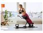Frau trainiert auf einem Bauchtrainer mit einer 6 kg Kettlebell, eine 8 kg Kettlebell liegt auf dem Boden.