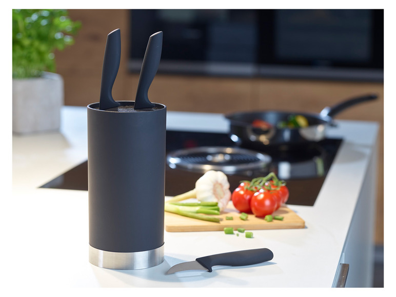 Ein schwarzer Messerblock mit Messern auf einer weißen Küchenarbeitsplatte.