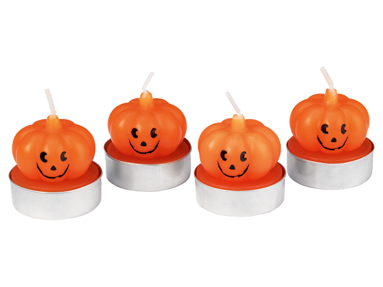 Vier Halloween-Kürbis-Teelichter mit lächelnden Gesichtern.