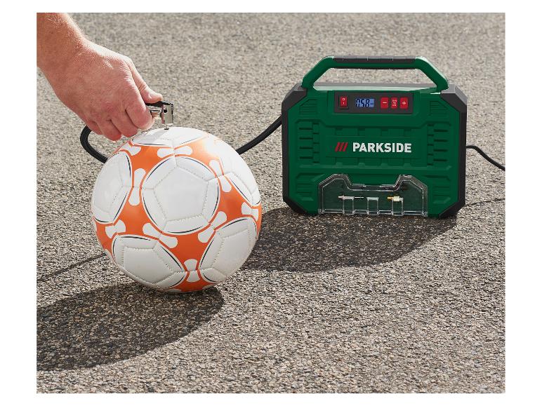 Mann pumpt einen Fußball mit einem grünen Luftkompressor auf.