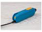 Ein blaues und oranges Handheld-Elektronikgerät mit schwarzem Kabel auf einer hellen Holzoberfläche.