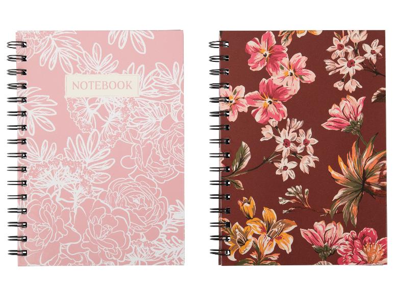 Zwei florale Spiralnotizbücher, eines rosa mit weißen Umrissen, eines braun mit bunten Blumen.