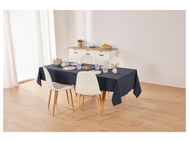 Tischdecke, Stühle und Geschirr auf einem Esstisch.