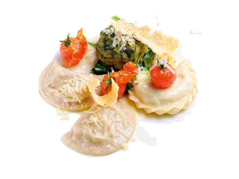 Ravioli mit gefüllten grünen Bällchen, Kirschtomaten und Parmesan.