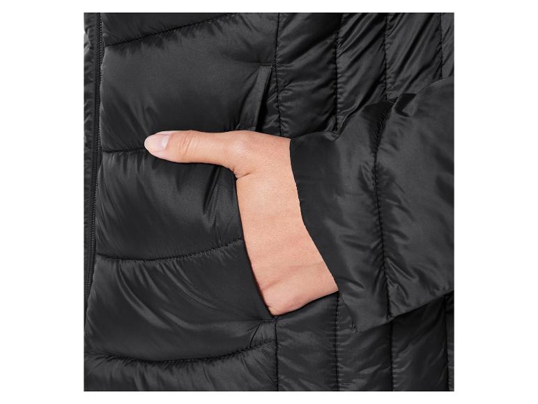 Nahaufnahme einer schwarzen Steppjacke mit einer Hand in der Tasche.