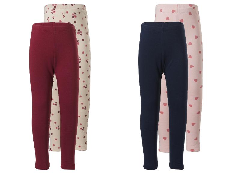 Zwei Sets Kinderleggings: Bordeaux und Creme mit Blumen, Marineblau und Rosa mit Herzen.