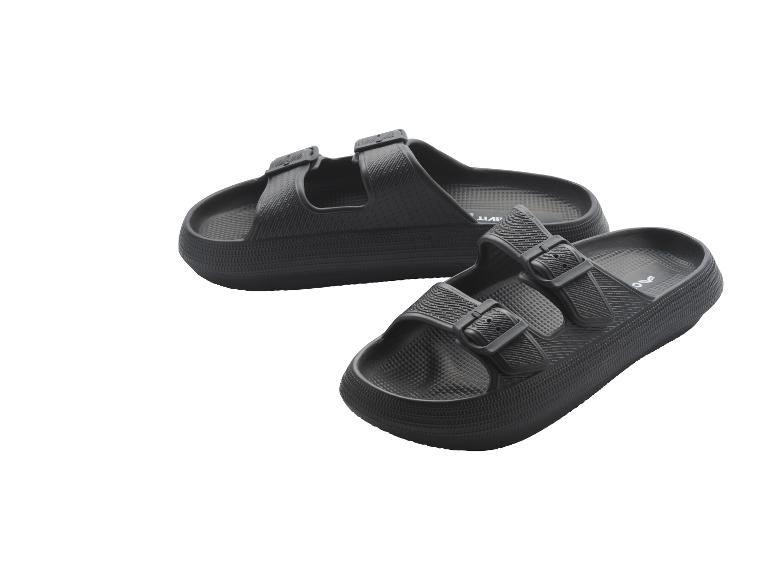 Ein Paar schwarze Sandalen mit zwei Riemen und Schnallen.
