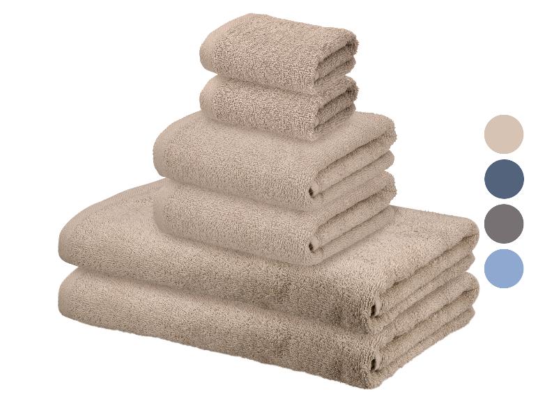 Ein Set beiger Handtücher in verschiedenen Größen gestapelt, mit Farbmustern an der Seite.