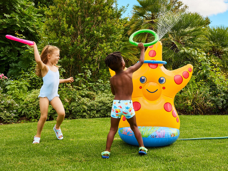 Zwei Kinder spielen mit einem aufblasbaren Seestern-Sprühspielzeug im Garten.