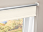 Ein weißes Rollo mit silberner Schiene, an einem Fenster montiert.