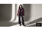 Frau in weinroter Daunenjacke, schwarzem Pullover, weiter Hose und Stiefeln.