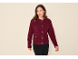 Frau in bordeauxfarbener Bouclé-Strickjacke mit Goldknöpfen und schwarzer Hose.