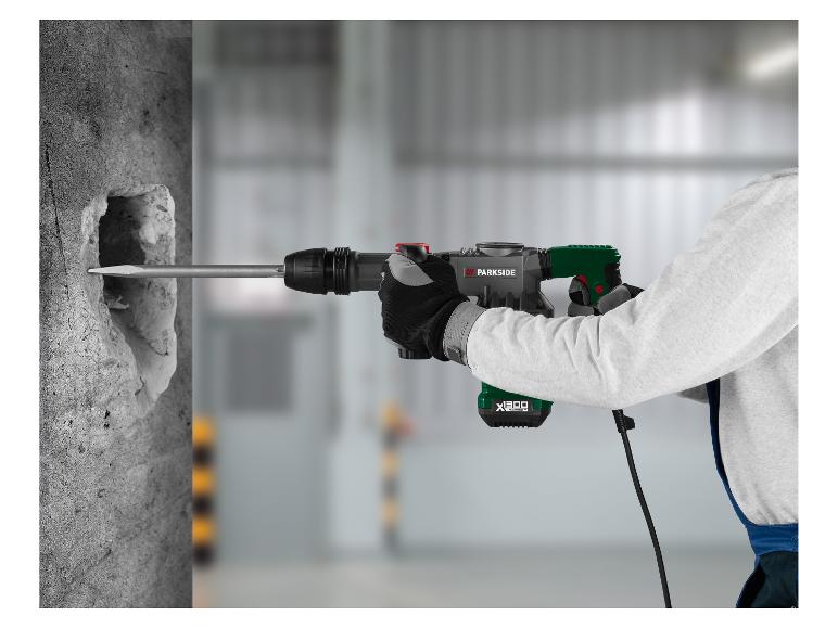 Ein Arbeiter benutzt einen Bohrhammer, um ein Loch in eine Betonwand zu bohren.