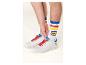 Weiße Sneaker mit roten Schnürsenkeln und gestreiften Socken mit einem farbigen Logo.