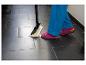 Person mit Dampfmopp reinigt Boden, trägt rosa Sandalen und blaue Hose.
