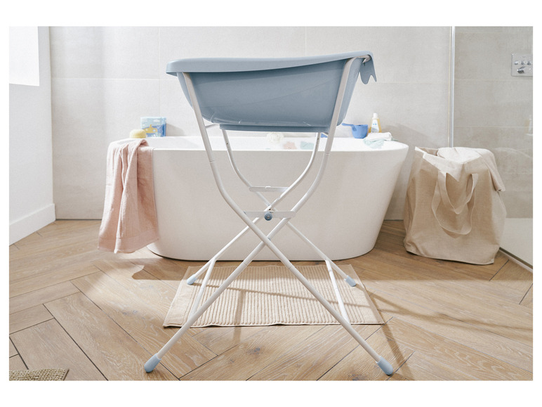 Eine blaue Babybadewanne auf einem Holzboden im Badezimmer.