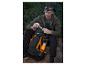 Mann mit Stirnlampe sitzt auf dem Boden und öffnet einen schwarzen Crivit Wanderrucksack.
