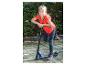 Lächelndes Mädchen in rotem T-Shirt und Jeans, das sich auf einen blauen Roller lehnt.