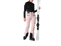 Eine Frau in rosa Skihose und schwarzem Langarmshirt hält Ski.