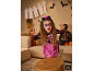 Mädchen in Halloween-Skelettkostüm mit Gesichtsbemalung und Spinnen-Tischdekoration. [KI-generiertes Bild]