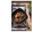 SILVERCREST® Gusseisen-Grillpfanne mit Lammkoteletts auf dem Herd.