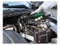 Hand benutzt einen Druckluft-Ratschenschrauber, um eine Autobatterie zu lösen.