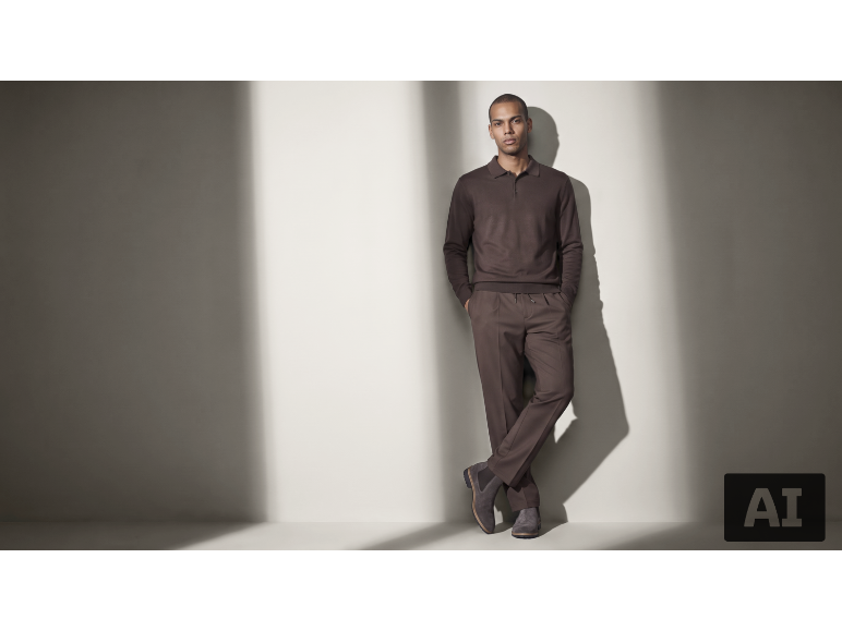 Mann in einem eleganten braunen Strick-Poloshirt und passender Hose.